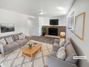 Living area featuring a brick fireplace and wood finished floors
