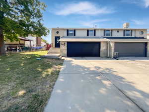 View of front facade featuring a garage, concrete driveway, and brick siding
