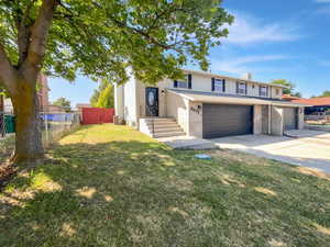 Traditional-style home featuring brick siding, concrete driveway, a chimney, and an attached garage