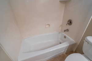 Bathroom with shower / washtub combination and tile patterned flooring