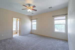 Empty room featuring light carpet and a ceiling fan