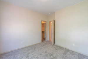 Unfurnished room featuring carpet and baseboards