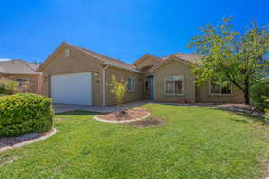 Single story home with stucco siding, driveway, a garage, and a front lawn