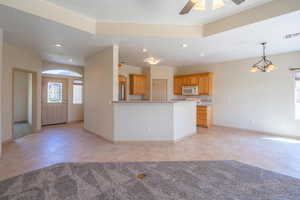 Kitchen featuring recessed lighting, light tile patterned flooring, pendant lighting, white microwave, and a chandelier