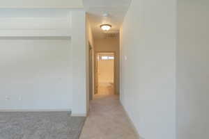 Hall featuring light colored carpet and light tile patterned floors