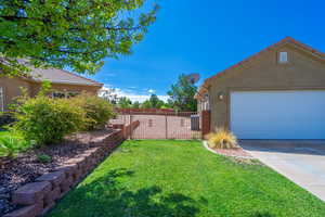 View of yard with a gate, driveway, and a garage