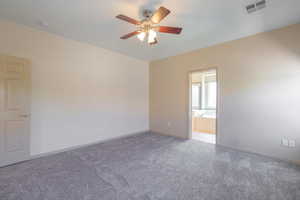 Carpeted spare room with a ceiling fan and baseboards
