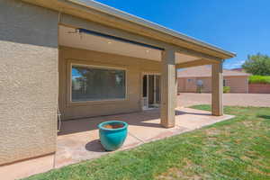 Back of property with a patio, stucco siding, and a lawn