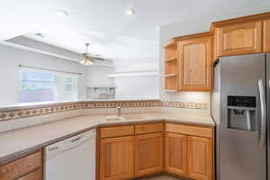 Kitchen featuring stainless steel fridge, dishwasher, tasteful backsplash, open shelves, and recessed lighting