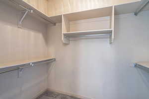 Spacious closet with dark carpet