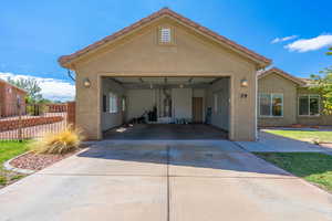 View of front of property with stucco siding, driveway, a garage, and gas water heater