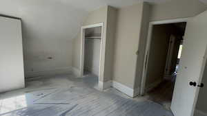 Additional living space with a textured ceiling, hardwood / wood-style floors, and vaulted ceiling