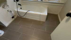 Full bathroom with dark tile patterned flooring and a garden tub