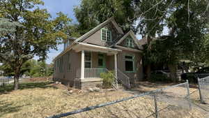 View of front facade featuring a fenced front yard, covered porch, and crawl space
