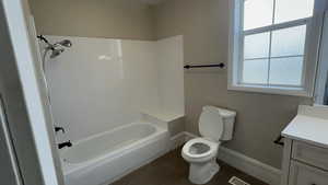 Full bathroom featuring vanity, tub / shower combination, and dark tile patterned floors