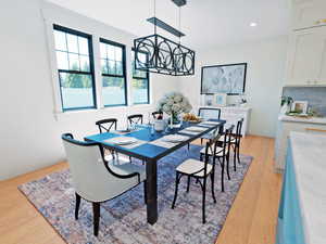 Dining room with a chandelier, light wood-type flooring, and recessed lighting