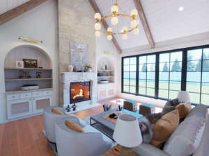 Living room with a premium fireplace, beam ceiling, high vaulted ceiling, wood finished floors, and a chandelier