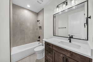 Full bathroom featuring shower / tub combination, vanity, light tile patterned floors, and recessed lighting