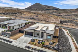 View of front of house with concrete driveway, a mountain view, and a garage