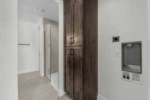 Hall with baseboards and light tile patterned floors