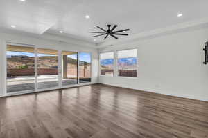Spare room featuring wood finished floors, a mountain view, a raised ceiling, recessed lighting, and ceiling fan