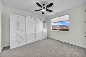 Unfurnished bedroom with light colored carpet and ceiling fan