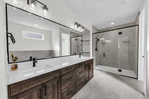 Full bathroom featuring a stall shower, double vanity, recessed lighting, and light tile patterned floors