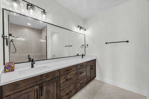 Bathroom featuring a stall shower, double vanity, and light tile patterned floors