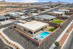 Aerial perspective of suburban area featuring a pool and a mountainous background