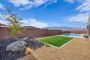 Fenced backyard with a mountain view and a patio