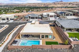 Aerial view of residential area featuring a mountain backdrop and a pool