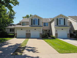Traditional home with driveway, a garage, and brick siding