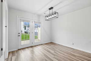 Dining area featuring light wood style vinyl floors with French doors leading out to private patio