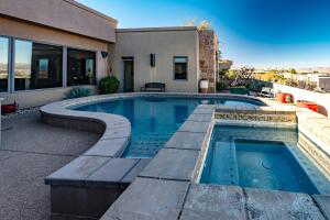 Outdoor pool with an in-ground hot tub and a patio area