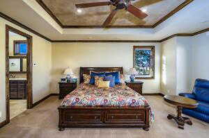 Bedroom with crown molding, a raised ceiling, ceiling fan, and carpet floors
