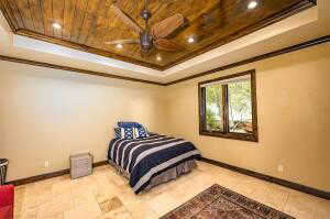 Bedroom with a raised ceiling, crown molding, wooden ceiling, recessed lighting, and light tile patterned floors