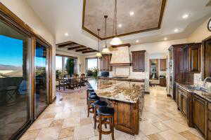 Kitchen with a tray ceiling, a center island, pendant lighting, recessed lighting, and a breakfast bar area