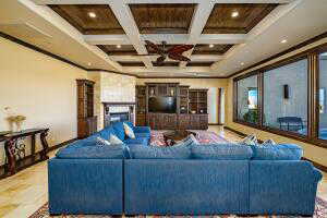 Living room featuring beam ceiling, coffered ceiling, ornamental molding, recessed lighting, and a fireplace