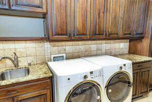Washroom featuring cabinet space and washer and dryer