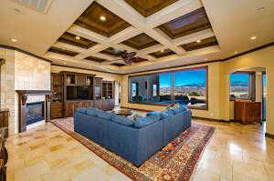 Living area featuring crown molding, a fireplace, beamed ceiling, coffered ceiling, and recessed lighting