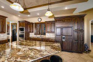 Kitchen featuring a kitchen bar, recessed lighting, pendant lighting, dark brown cabinetry, and a tray ceiling