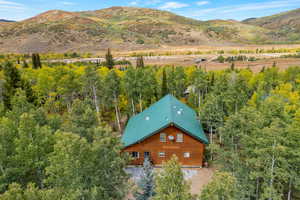 Aerial view of property and surrounding area with a mountain backdrop
