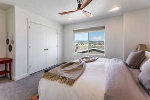 Bedroom with carpet, a textured ceiling, a closet, and ceiling fan