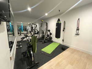 Workout area with wood finished floors and recessed lighting