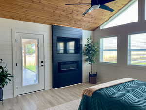 Bedroom featuring wooden ceiling, wood walls, access to outside, lofted ceiling, and wood finished floors