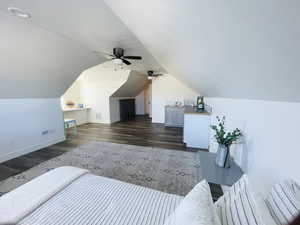 Bedroom featuring a textured ceiling, dark wood-style floors, a ceiling fan, and vaulted ceiling