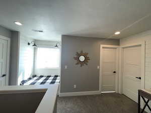 Bedroom featuring dark colored carpet, a textured ceiling, and recessed lighting