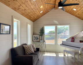 Sitting room with wood finished floors, wooden walls, wooden ceiling, lofted ceiling, and recessed lighting