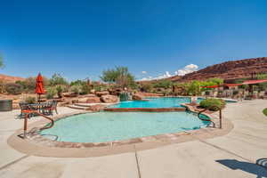 Community pool with a patio, a mountain view, and a hot tub
