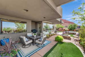 View of patio with a fire pit, a grill, outdoor dining area, and a mountain view